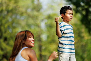 Obraz premium Young boy in striped shirt enjoying a scenic day with smiling woman nearby