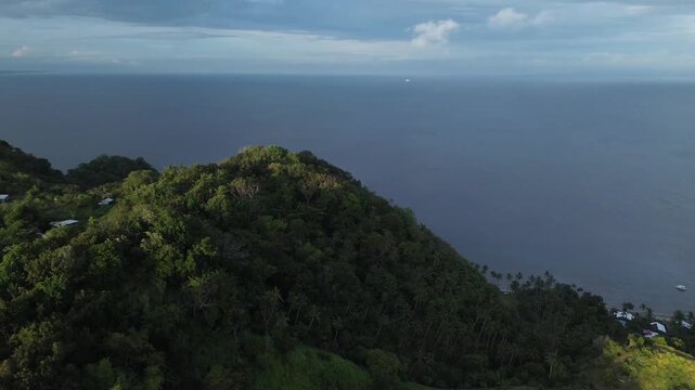 Aerial drone view of lush green hills and mountains on Apo Island Philippines with ocean in background and tropical landscape. Cinematic 4K footage ideal for travel nature and scenic visuals.