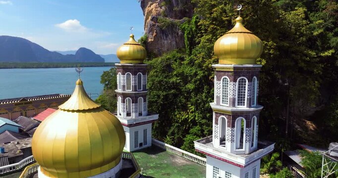 Minarets And Golden Domes Of Koh Panyee Mosque Surrounded By Stilt Houses In Phang Nga, Thailand. pullback drone shot