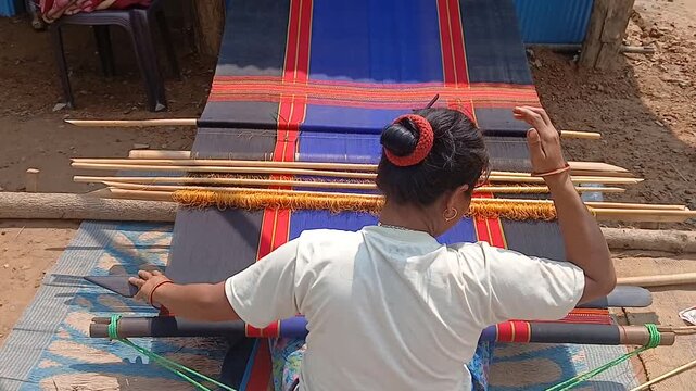 Loin loom weaver working in loom.	