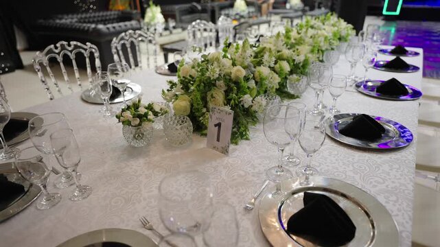 Elegant wedding reception table with beautiful floral centerpiece and number card.