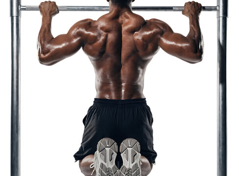 Strong athletic man doing pull ups on a horizontal bar displaying powerful back muscles and intense physical fitness training isolated on a transparent background