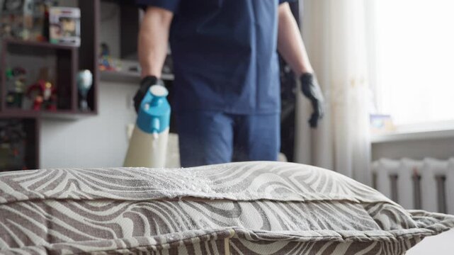 Caucasian Cleaner Spraying Pillows For Cleaning And Sanitizing, Handheld Misting Dispenser Applying Fine Mist Across Patterned Pillowcase, Gentle Refresh And Allergen Treatment In Bedroom