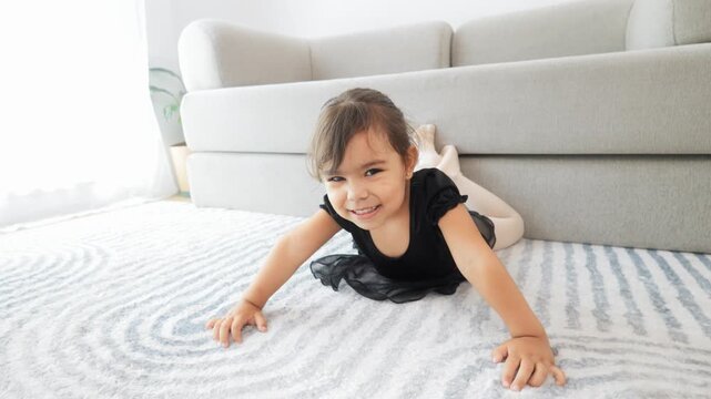 Little ballerina girl have fun practicing ballet at home. Happy child wearing dance costume