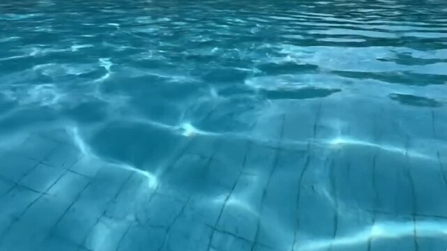 Vibrant Blue Swimming Pool Water Surface with Mesmerizing Sunlight Reflections Creating Dynamic Underwater Patterns
