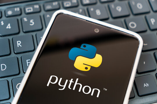 Programming language for mobile development, concept. Smartphone on the laptop keyboard. logo python on the mobile phone screen.