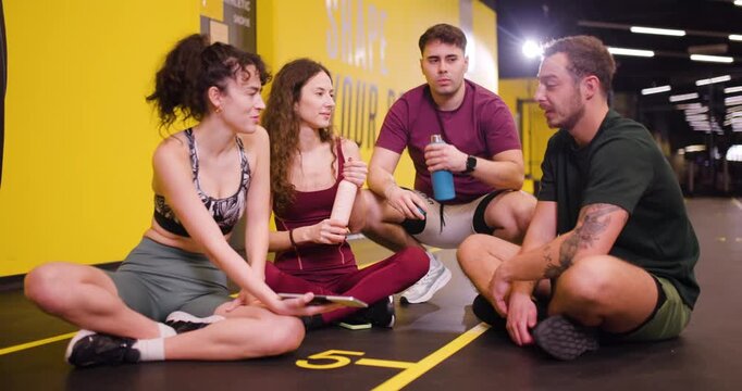 Group of friends meets at fitness center to share tips and enjoy exercise together during their workout session