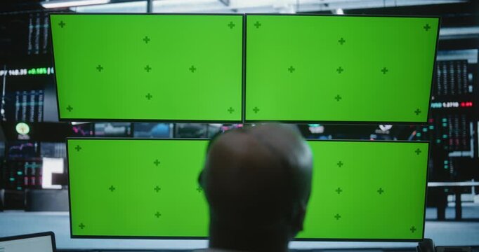 African American Male Trader Working at Modern High Tech Desk With Four Green Screen Monitors in Busy Financial Office. Concept of Financial Data, Software Demos, and Corporate Presentations.
