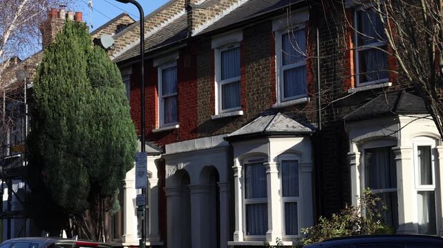 Row house residential building with red brick facade and bay windows