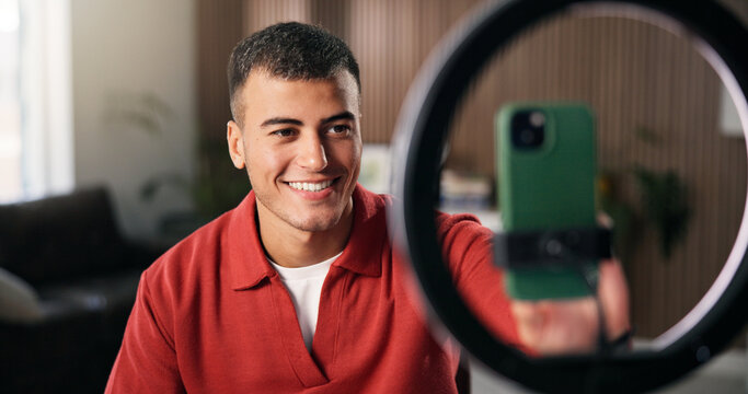 Man, streamer and phone with ring light in home for content creation, influencer and recording video. Person, smartphone and influence with smile, mobile app and social network post at apartment