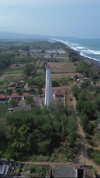 aerial video of lighthouse on the south coast of Java with a blue sea background with big rippling waves