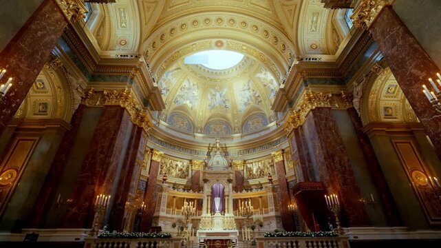 A low-angle view of a baroque church tower against a blue sky.