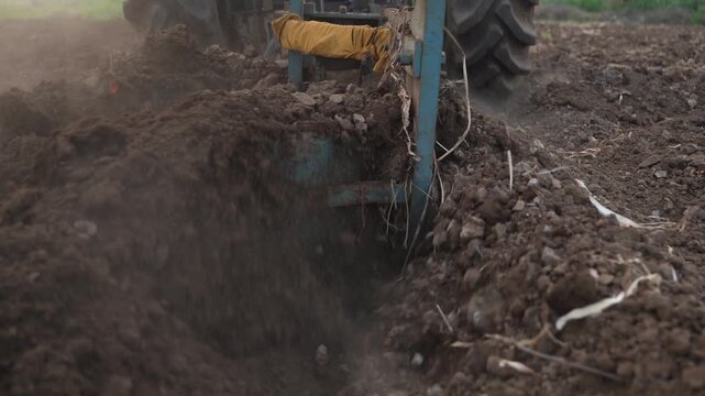 indian Farmer plowing agriculture field with tractor 