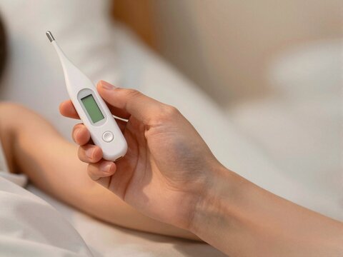 Adult Hand Holding Digital Thermometer Under Child's Arm