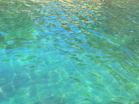 The surface of clear sea water with a turquoise hue.