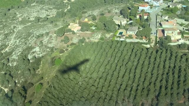 Aerial left side view of the shadow on a medium size twin-engine jet captured from cockpit while approahing to Valencia airport runway (VLC), flying over a residential area.