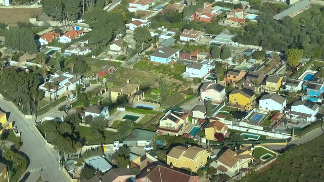 Left side cockpit view of the shadow of a medium size twin-engine jet flying at low altitude over a residential area in the final approach to the runway. of Valencia airport.