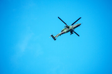 Naklejka premium Helicopter is flying on isolated blue sky in mid-air background.