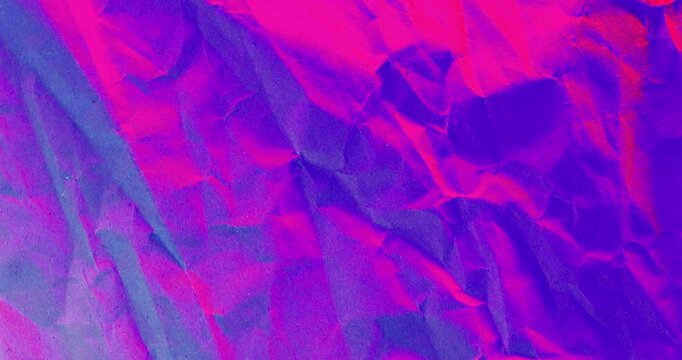 Crumpled Neon Paper Texture Abstract. Seamless loop of crumpled paper surface with sharp folds and wrinkles illuminated by vibrant pink purple and blue neon lighting creating dramatic color shifts.
