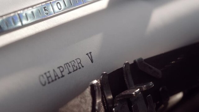 Writer types chapter five on a typewriter in a cozy home office setting during afternoon