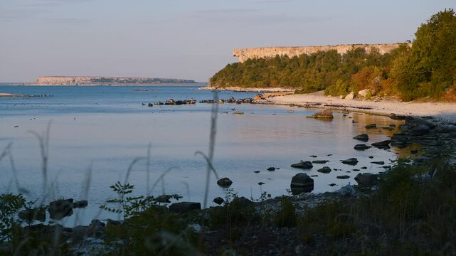 Closer view of Stora Karls&ouml; cliffs and coastline at sunset with Lilla Karls&ouml; island on the horizon, Gotland, Sweden