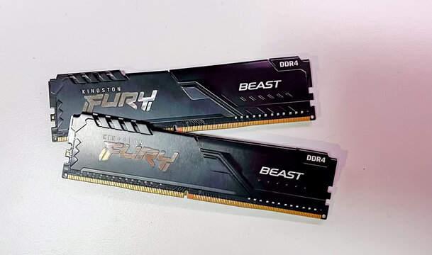 A close-up of two Kingston Fury Beast DDR4 memory sticks placed on a white surface, designed for desktop computer upgrades