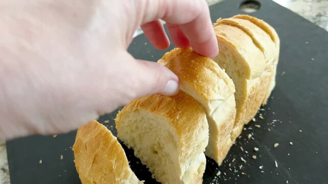 Person Lifting Sliced Bread From Board
