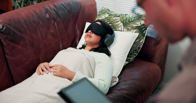 Psychology, treatment and woman on couch with headphones, relax or psychedelic counseling. Mental health, psilocybin therapy and person with sleep mask for anxiety, trauma or alternative medicine
