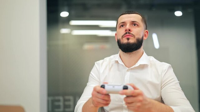 Adult man immersed in playing video games, exhibiting deep concentration and moments of enjoyment. Modern setting provides a backdrop for leisure, showcasing happiness and excitement during activity.