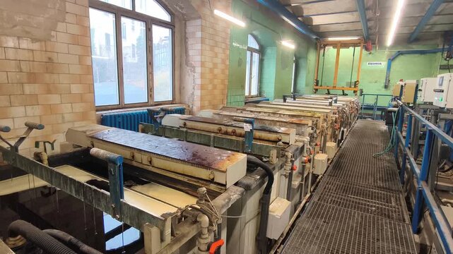Industrial galvanizing facility with metal tanks for zinc coating, production line and machinery inside factory hall in Czech Republic