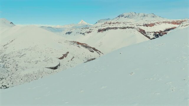 R&iacute;o Chico river meanders through snow covered Andean valley in Las Loicas near Paso Pehuenche Mendoza Argentina within R&iacute;o Grande basin surrounded by volcanic peaks and winter terrain, aerial reveal