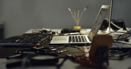 Fototapeta na wymiar Laptop, repair and work desk with components for electronic maintenance or fix in workshop. Empty, computer or IT engineering with equipment for problem solving, troubleshooting or circuit testing