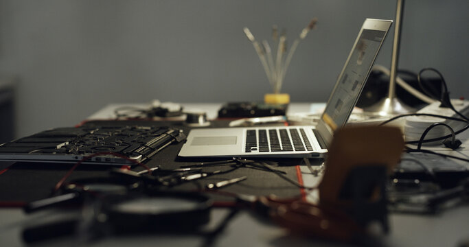 Laptop, repair and work desk with components for electronic maintenance or fix in workshop. Empty, computer or IT engineering with equipment for problem solving, troubleshooting or circuit testing