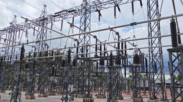 Cinematic right panning shot of outdoor high voltage power grid substation.