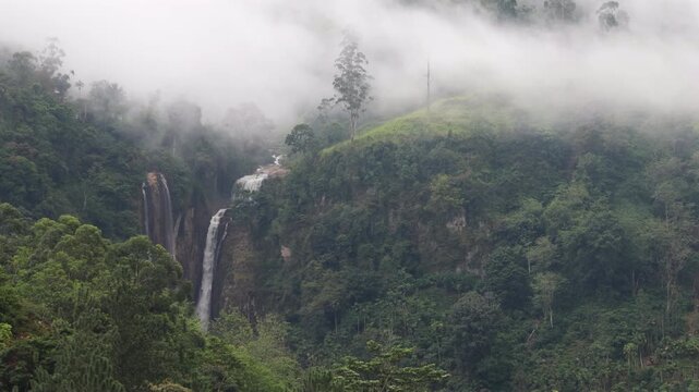 Mountain landscape near Nuwara Eliya in Sri Lanka. Misty Mountain Waterfall: Serene Green Landscape with Flowing Falls and Ethereal Fog, Nature's Tranquil Beauty