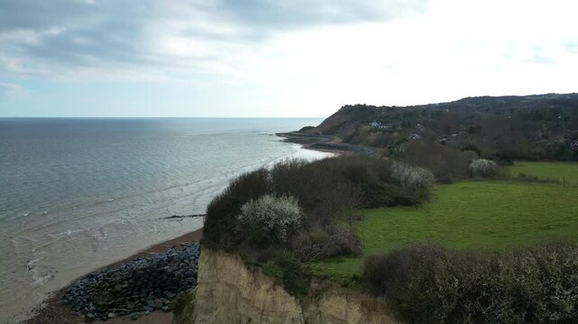 Drone forward glide revealing rugged Fairlight Cove beach on the Sussex coast, UK, bright spring coastal landscape.
