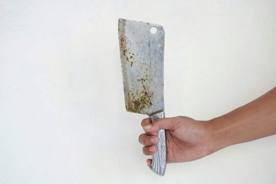 Close up of an Asian man's hand holding a butcher knife against a white background