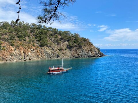 Panoramic view of the calm Mediterranean Sea and yacht among the mountains near Camyuva, Kemer, Turkey.