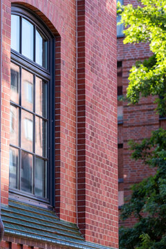 Vertical urban brick building window detail with heritage texture on an architectural facade creating a timeless pattern for designers