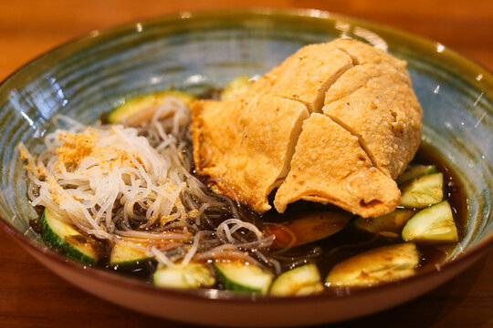 A serving of empek-empek kapal selam, Indonesian fish cake stuffed with egg, served with savory sauce.