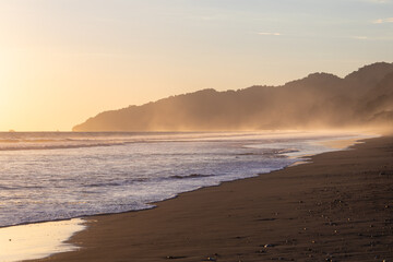 The low sun's golden light illuminates the ocean spray on Carate Beach, with views of Corcovado NP at sunset. Costa Rica. © jiriviehmann