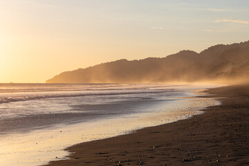 The low sun's golden light illuminates the ocean spray on Carate Beach, with views of Corcovado NP at sunset. Costa Rica. © jiriviehmann
