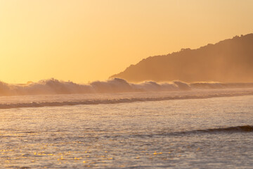The low sun's golden light illuminates the ocean spray on Carate Beach, with views of Corcovado NP at sunset. Costa Rica. © jiriviehmann