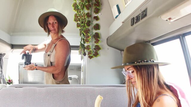 Lesbian couple enjoying van life while making coffee
