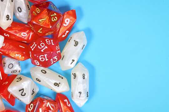 Roleplay game background with different red and white RPG dices at side of light blue background with copy space