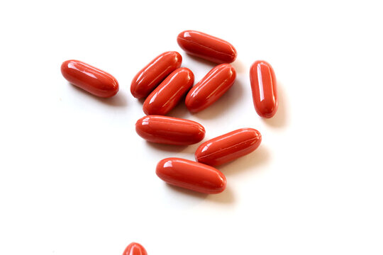 Collagen capsules supplement in red bottle cap on white table