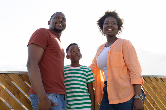 African American family standing on deck with diagonal railing looking upward woman wearing watch