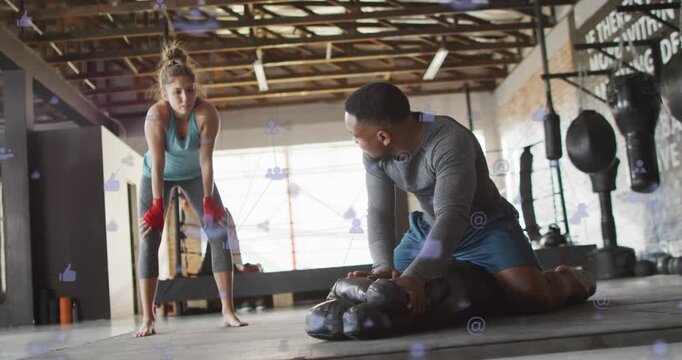 Trainer positioning mannequin kneeling and doing CPR for training in gym, icons overlaying
