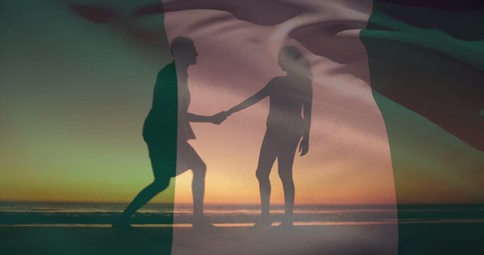 Talking couple stepping closer, kneeling man proposing on beach sunset with flag in beachwear