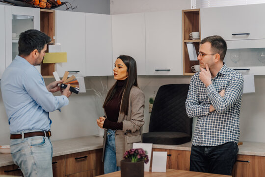 Couple consulting designer choosing kitchen materials for home renovation